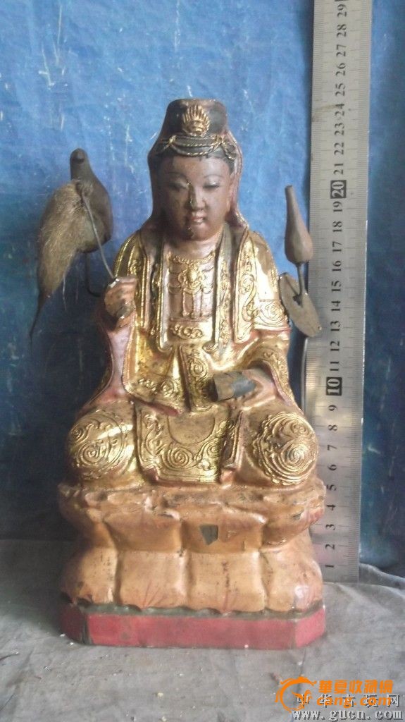 木雕观音像,手拿拂尘,身后还有净瓶和一只神鸟
